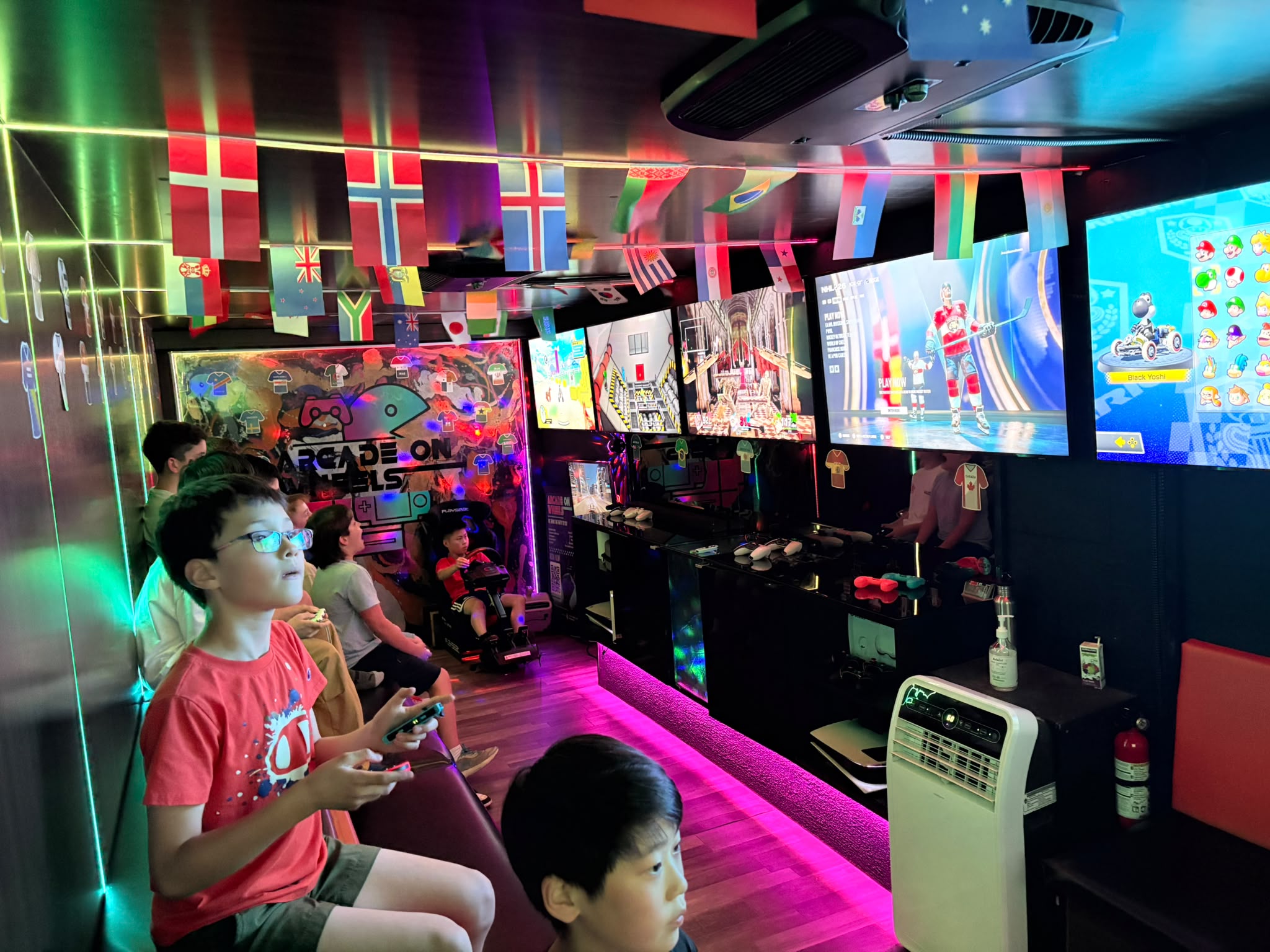 Inside the gaming trailer with big screens and players